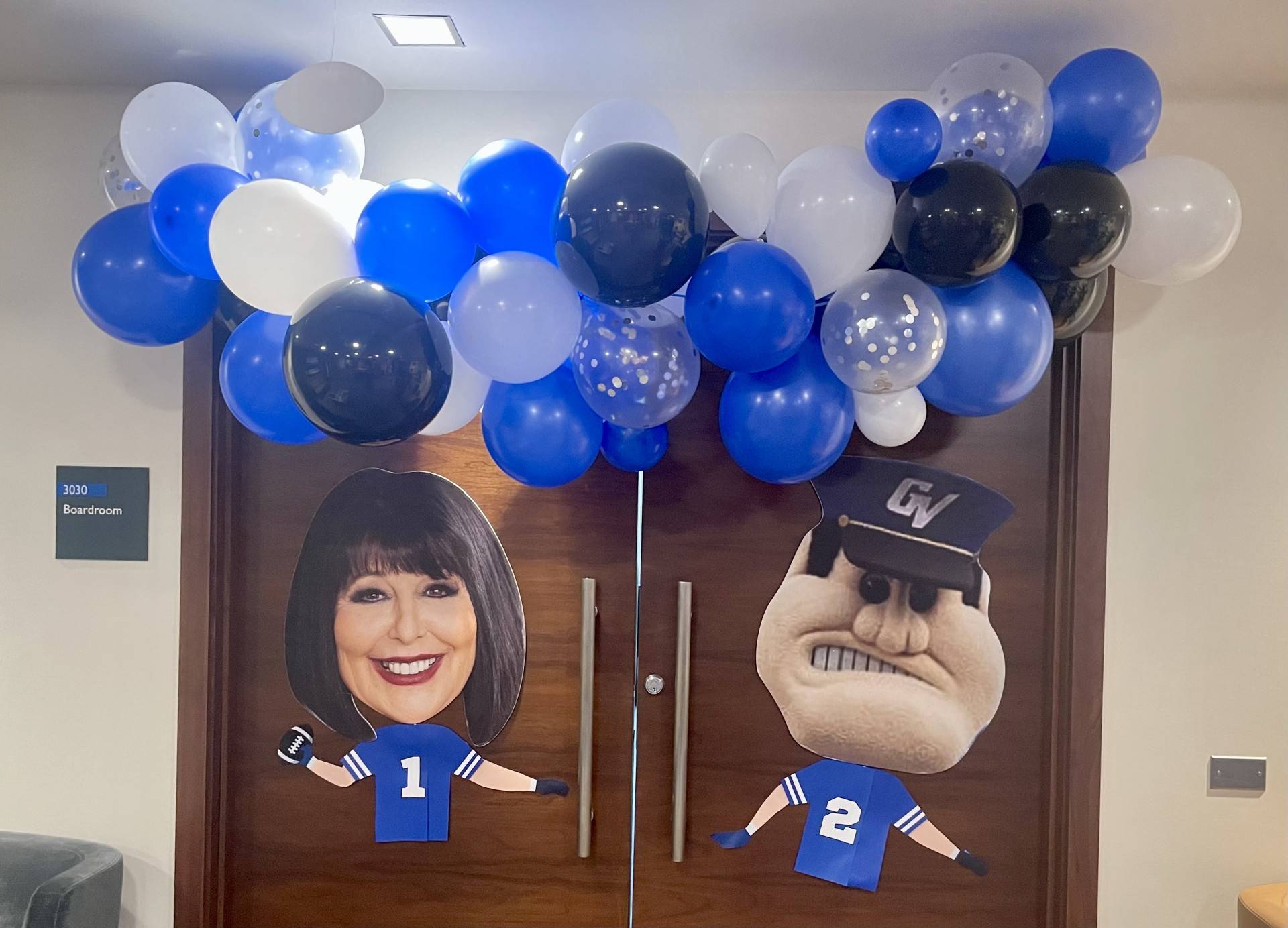 President's Office Homecoming decor, Philly and Louie's head cutouts on double doors with a balloon arch above